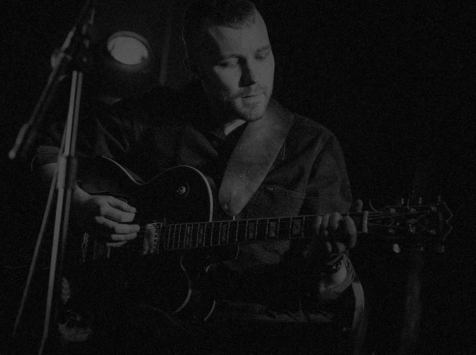 Bartek Pydynkowski grający na gitarze na scenie
